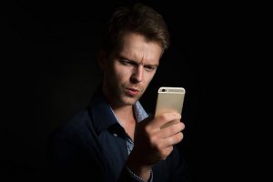 mezczyzna trzymajacy telefon 300x200 4 pytania, na które musisz odpowiedzieć, jeśli masz problem z logowaniem się do konta nju mobile i każdego innego operatora